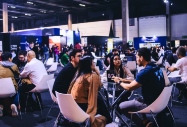 Público de profissionais da indústria de games conversando em uma área de networking durante a gamescom latam no Distrito Anhembi.