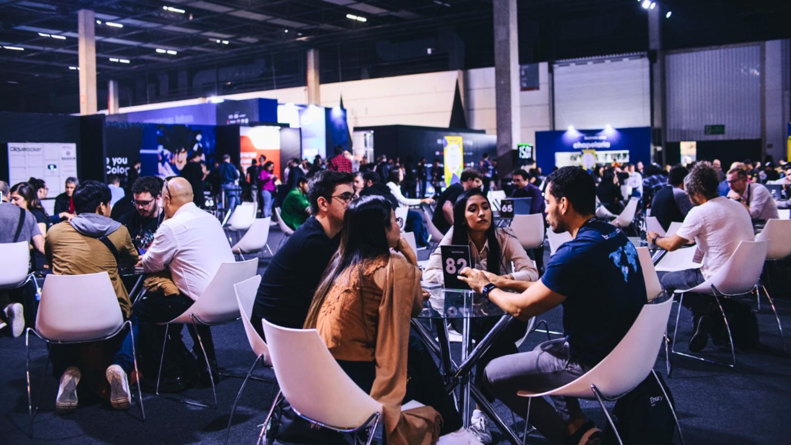 Público de profissionais da indústria de games conversando em uma área de networking durante a gamescom latam no Distrito Anhembi.