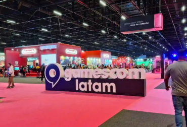 Público testando jogos independentes em estações de computador coloridas durante a edição anterior do BIG Festival no Distrito Anhembi.