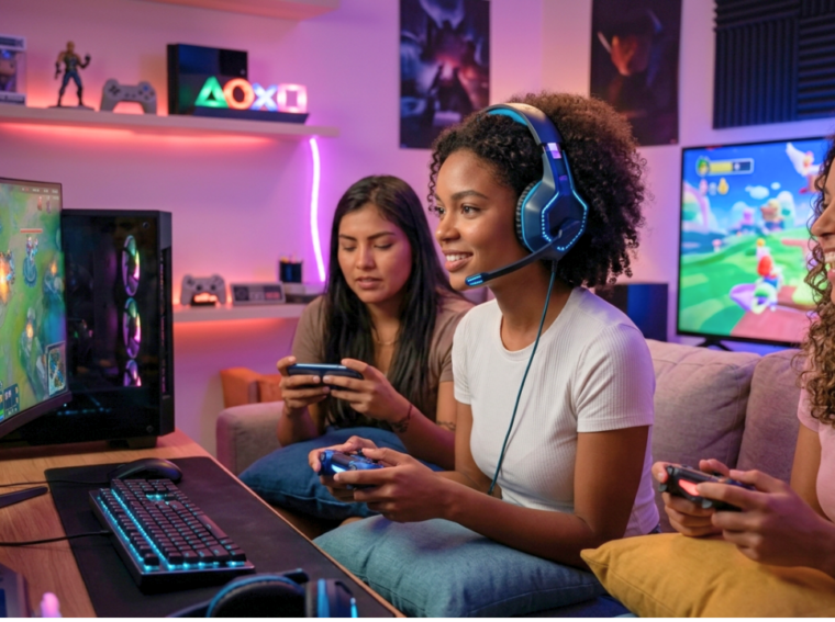 Mulher jovem negra utilizando um headset profissional e concentrada jogando em um setup de PC gamer, representando a maioria feminina de 52,8% apontada pela PGB 2026.